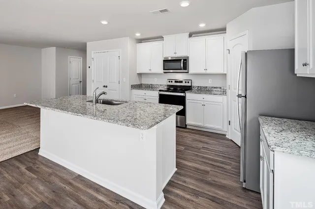 a kitchen with stainless steel appliances granite countertop a refrigerator stove microwave and sink