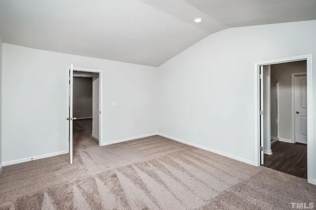 an empty room with closet and a bathroom