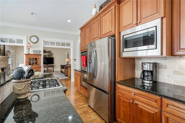 a kitchen with stainless steel appliances granite countertop wooden cabinets a sink and dishwasher