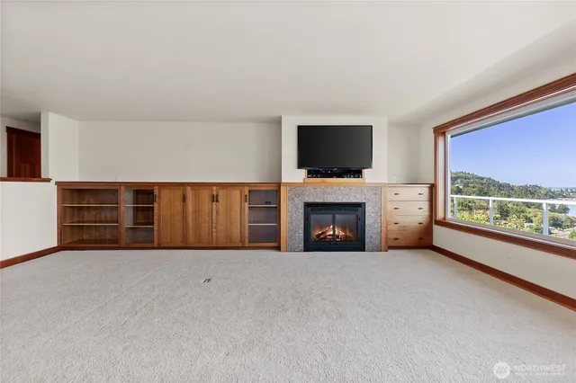 a view of an empty room with a fireplace and a window