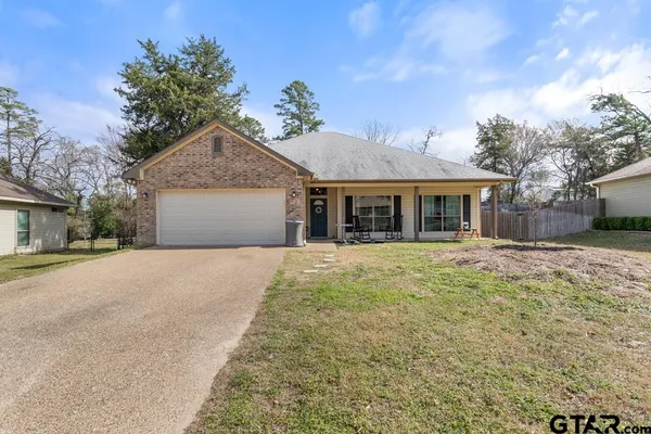 a front view of a house with a garden and yard