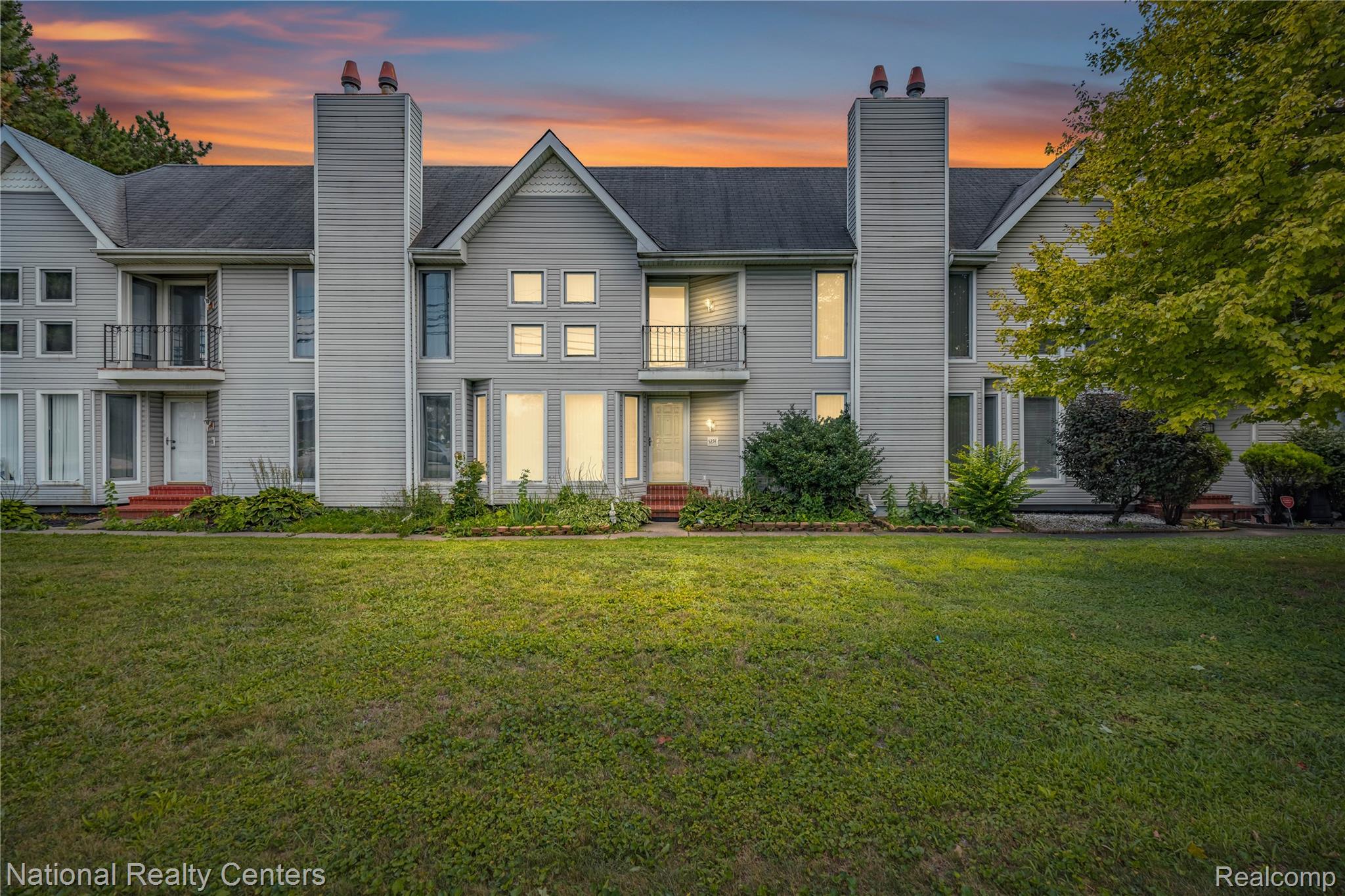 5274 East 14 Mile Road Warren, MI 48092 - Photo 1 of 31 Gray siding exterior with multiple balconies, prominent chimneys, and varying window configurations