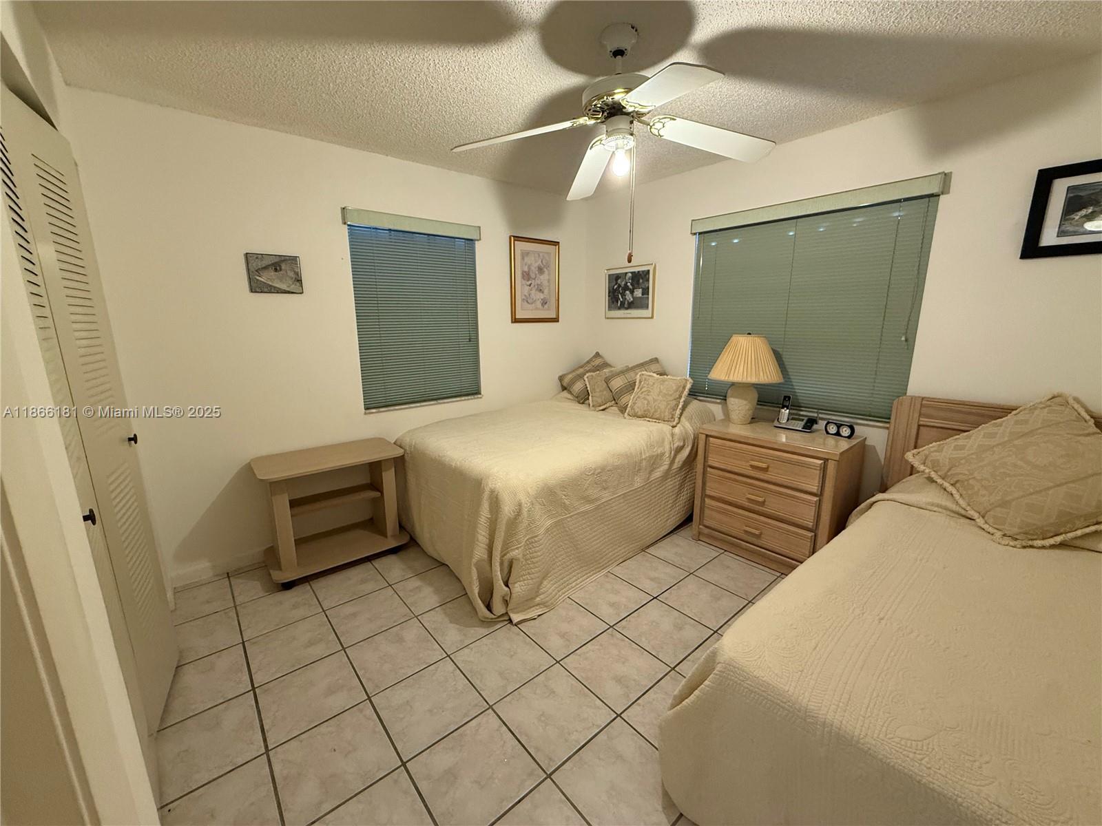 657 Waterside Drive, Unit 657 Hypoluxo, FL 33462 - Photo 12 of 17 a bedroom with double bed and a chandelier