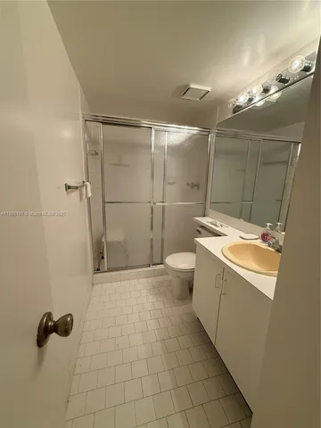 a bathroom with a granite countertop sink mirror and shower