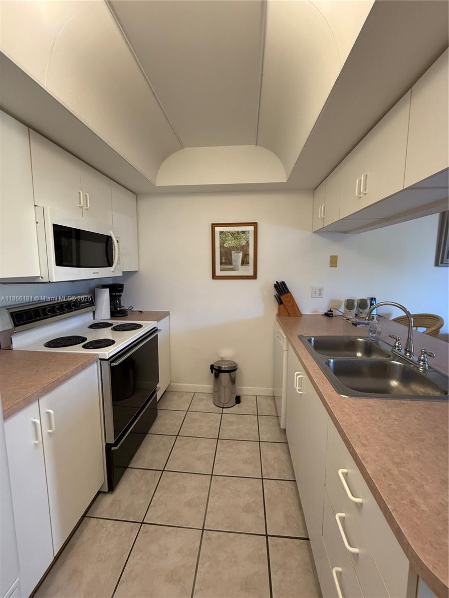 657 Waterside Drive, Unit 657 Hypoluxo, FL 33462 - Photo 2 of 17 a kitchen with a sink and a stove top oven