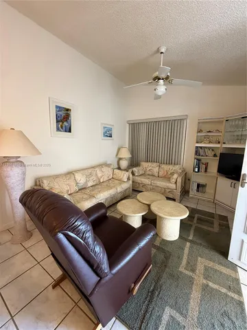 a living room with furniture a rug and a chandelier