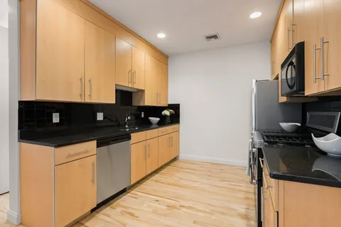 a kitchen with stainless steel appliances granite countertop a stove a sink and a microwave