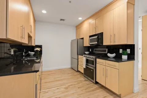 a kitchen with stainless steel appliances granite countertop a stove and a refrigerator