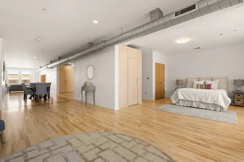 a spacious bedroom with a bed and glass table