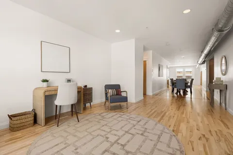 a living room with furniture and a wooden floor