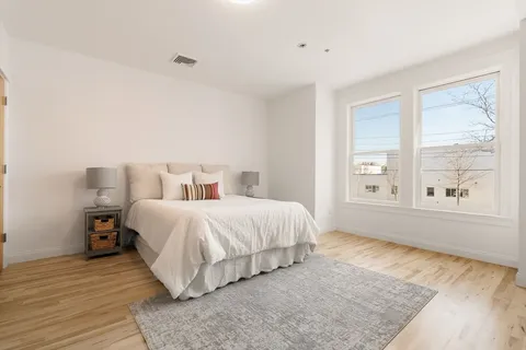 a bedroom with a bed and a large window