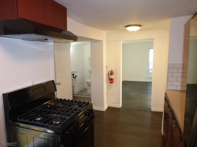 a kitchen with granite countertop a stove and a refrigerator