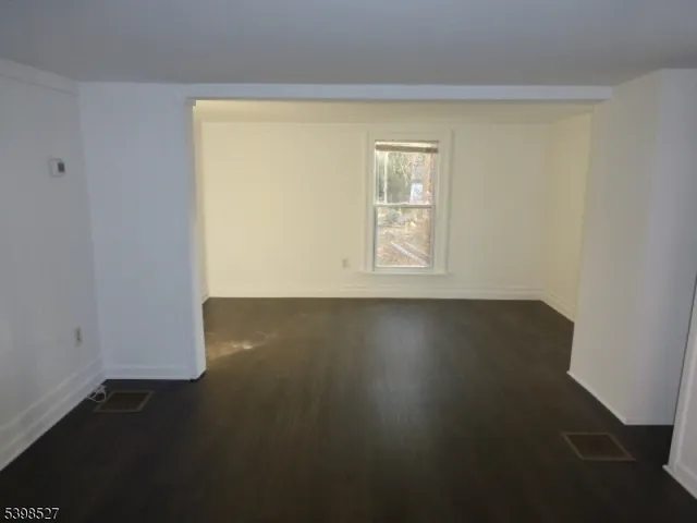 an empty room with wooden floor and a window