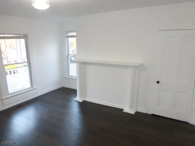 an empty room with wooden floor and cabinet