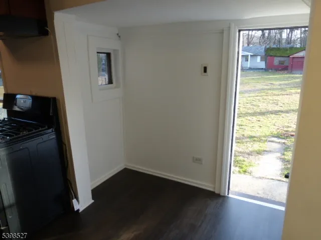 a view of a hallway with wooden floor and a bathroom
