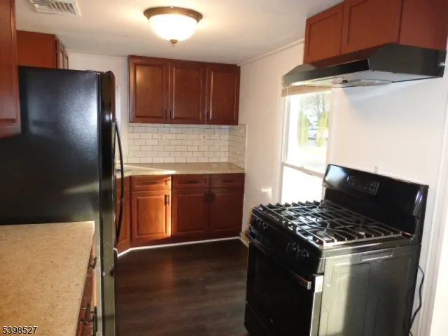 a kitchen with granite countertop a stove and a refrigerator