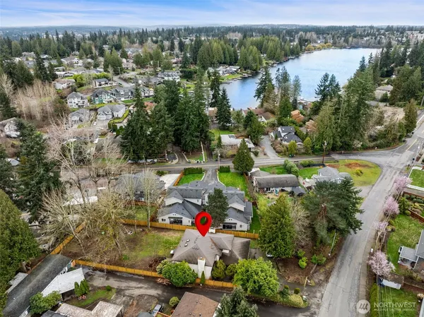 an aerial view of lake and residential houses with outdoor space and swimming pool