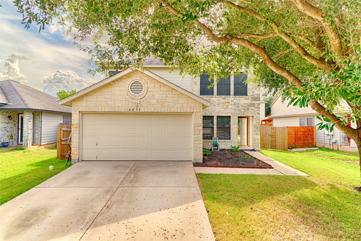 a front view of a house with a yard and garage