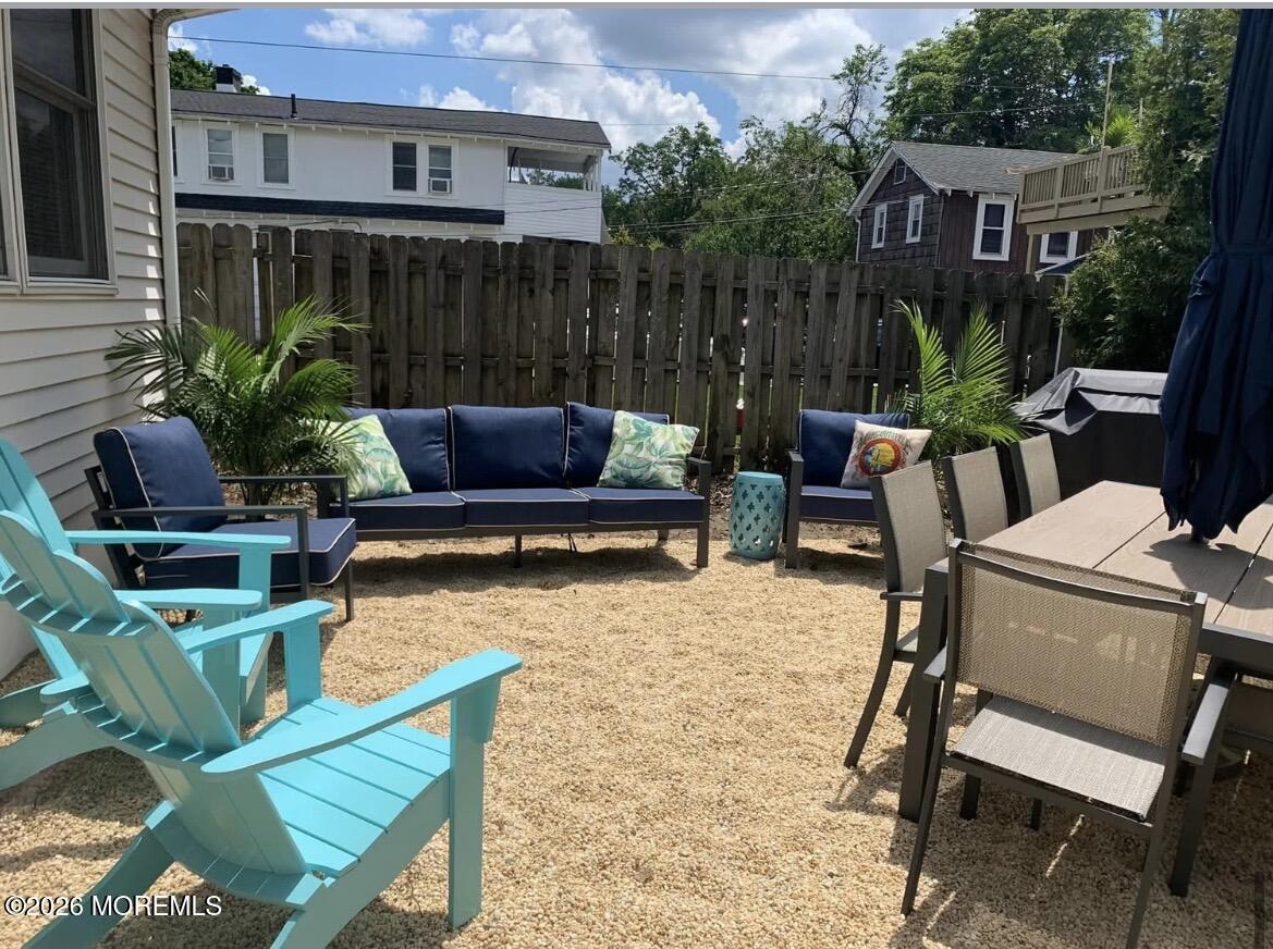 2001 Main Street Lake Como, NJ 07719 - Photo 25 of 26 a view of a patio with table and chairs potted plants and a wooden fence