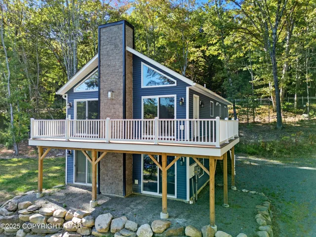 a deck that has a table and chairs next to a yard