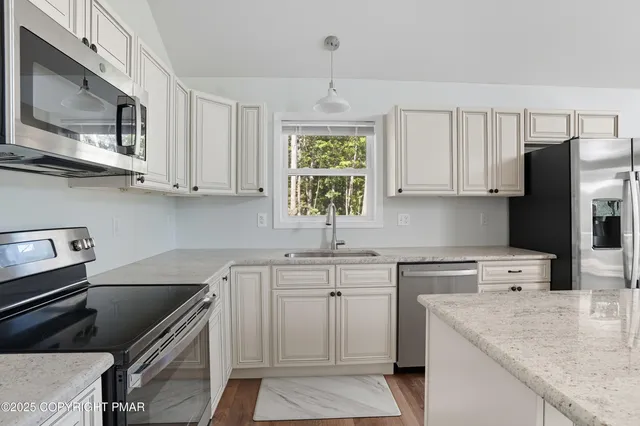 a kitchen with stainless steel appliances granite countertop a sink stove and refrigerator