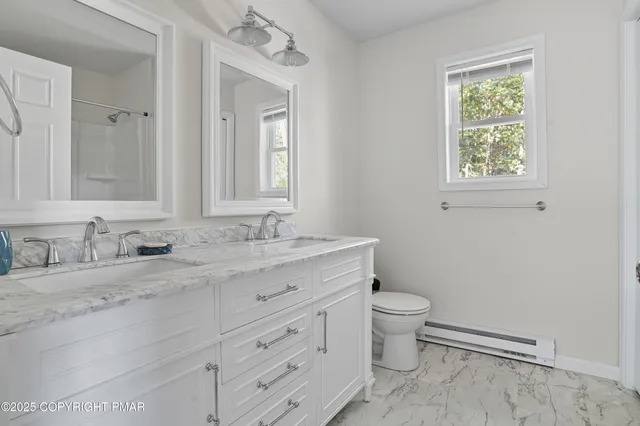 a bathroom with a granite countertop toilet sink and mirror