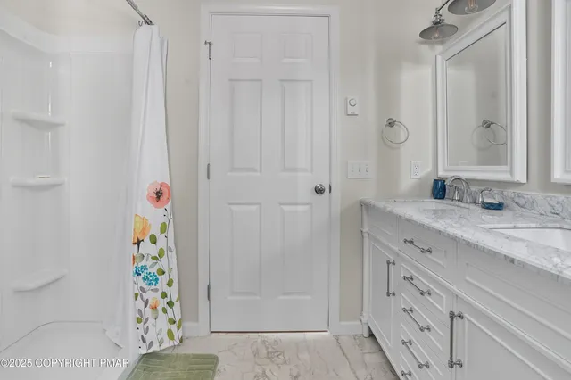 a bathroom with a granite countertop sink a toilet and a shower
