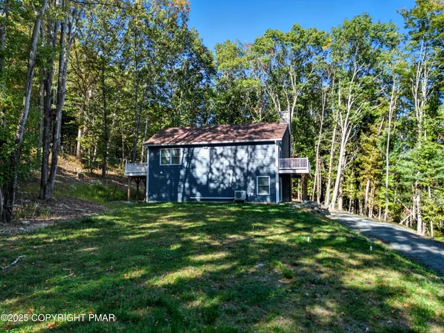 a view of a yard with chairs and a potted plant