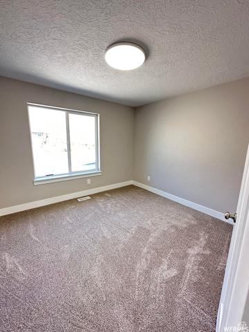 1171 West 2330 North Helper, UT 84526 - Photo 18 of 26 Carpeted empty room with a textured ceiling and baseboards