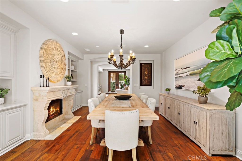5 Via Monarca Street Dana Point, CA 92629 - Photo 15 of 57 a dining room with wooden floor a fireplace a kitchen and a chandelier