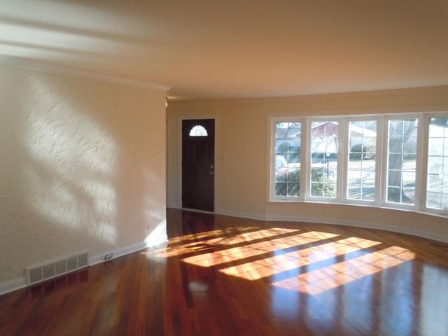 1752 East Corktree Lane Mount Prospect, IL 60056 - Photo 3 of 20 a view of an empty room with wooden floor and a window