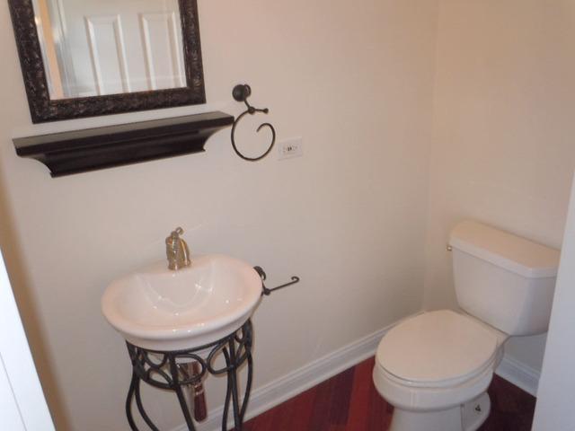 1752 East Corktree Lane Mount Prospect, IL 60056 - Photo 7 of 20 a bathroom with a toilet sink and mirror