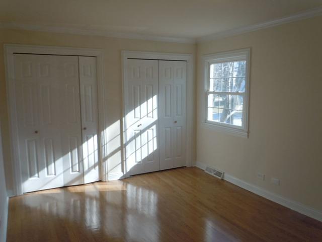1752 East Corktree Lane Mount Prospect, IL 60056 - Photo 9 of 20 a view of an empty room with wooden floor and a window