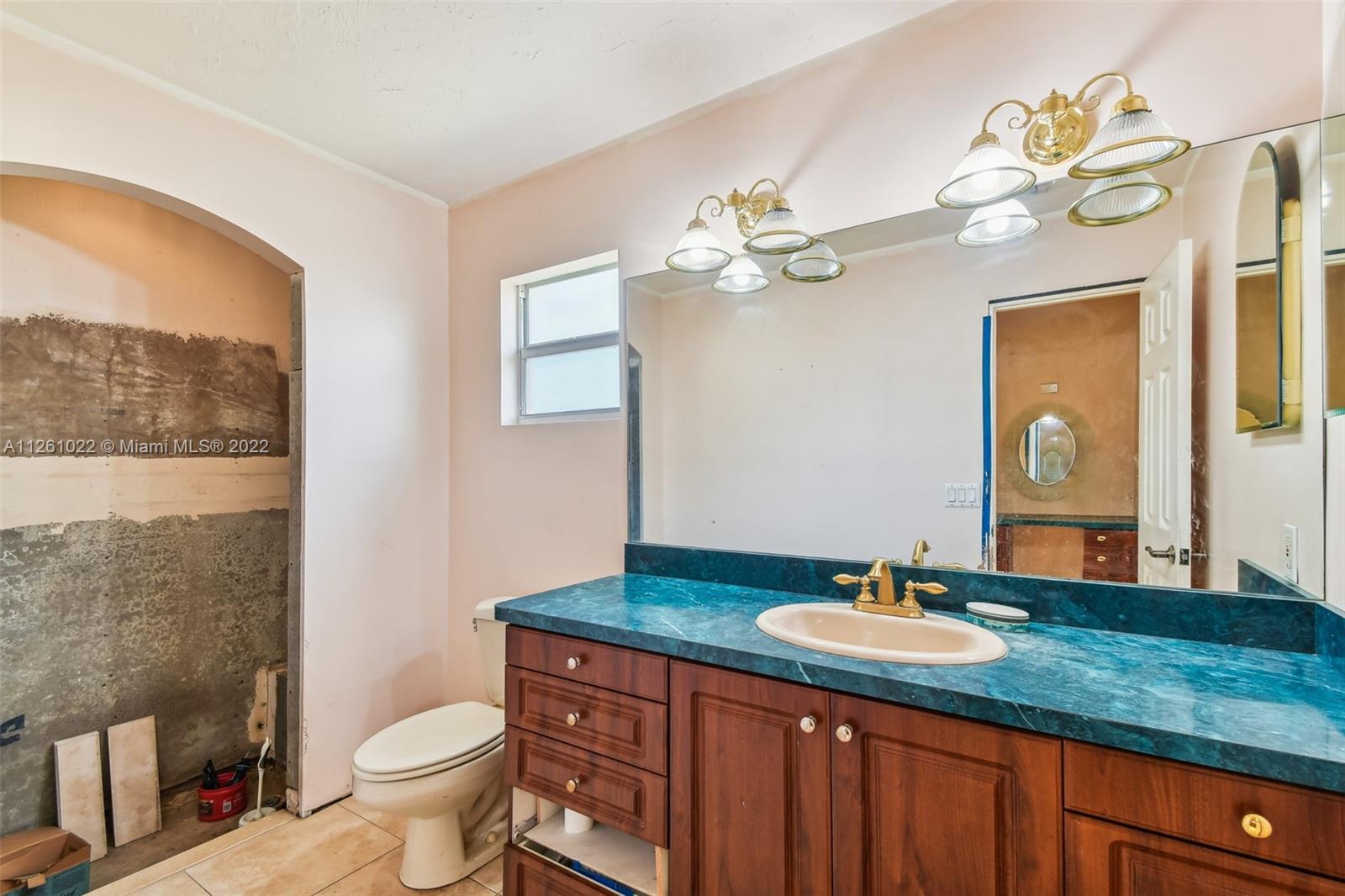 3008 Dunlin Road Delray Beach, FL 33444 - Photo 24 of 30 a bathroom with a granite countertop sink a toilet and a mirror