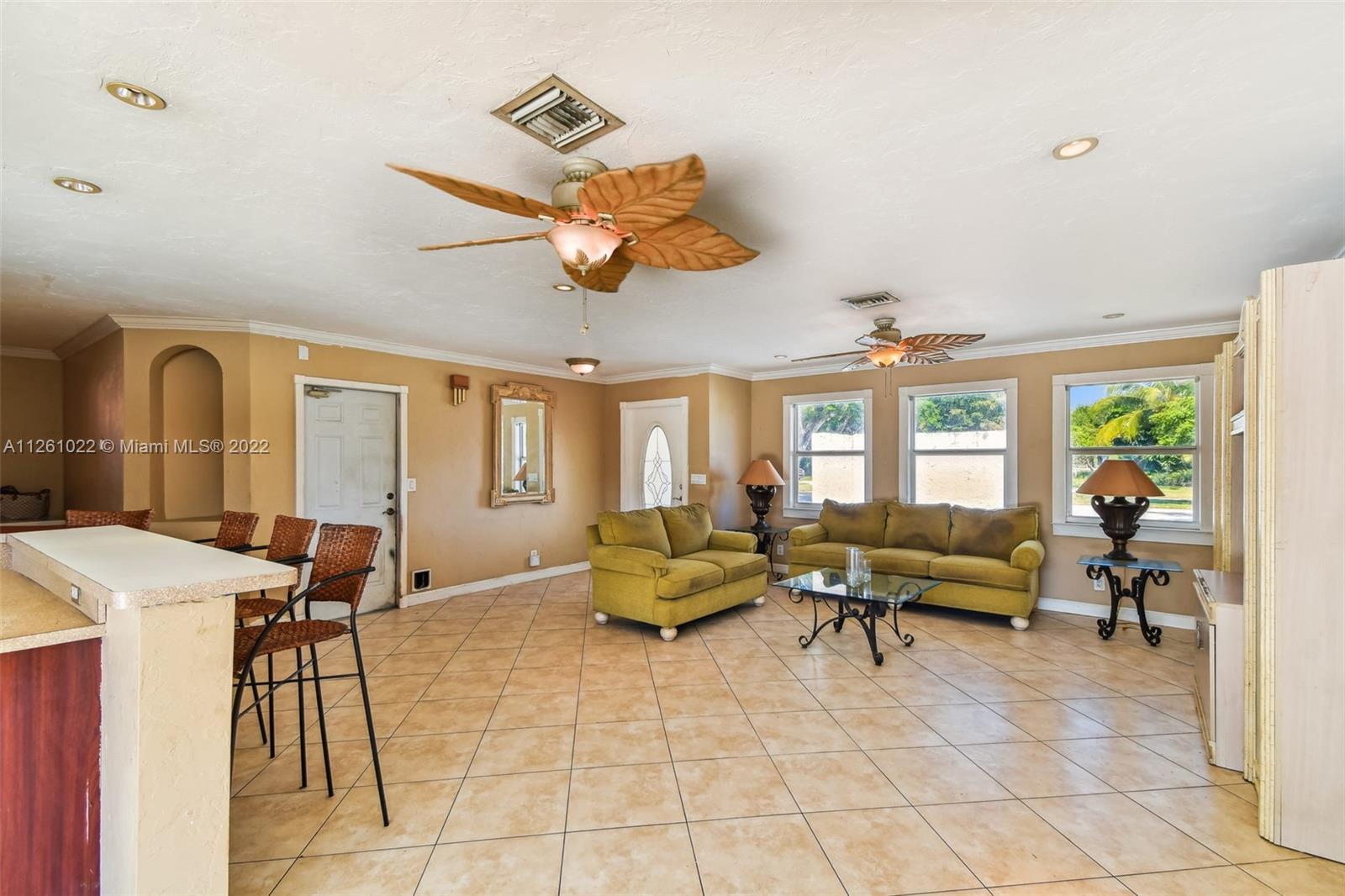 3008 Dunlin Road Delray Beach, FL 33444 - Photo 6 of 30 a living room with furniture a flat screen tv and a large window