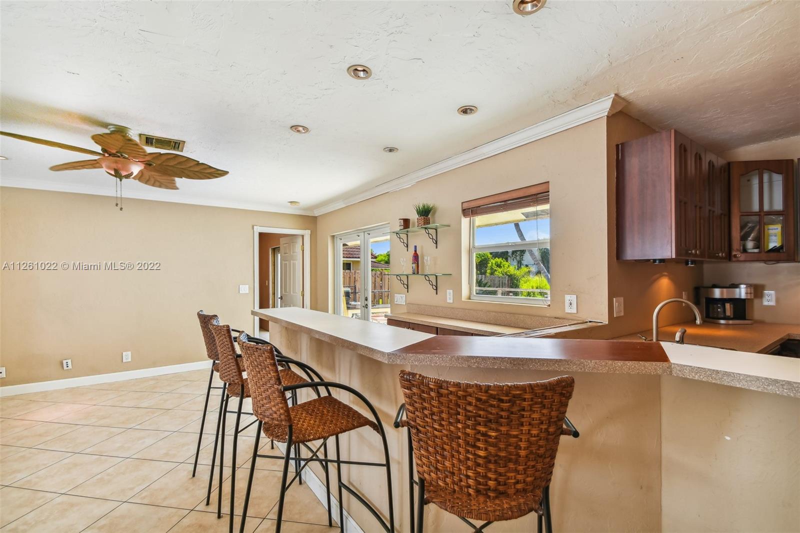 3008 Dunlin Road Delray Beach, FL 33444 - Photo 8 of 30 a kitchen with a table chairs and a refrigerator