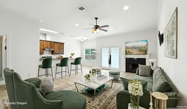 a living room with furniture a fireplace and a chandelier