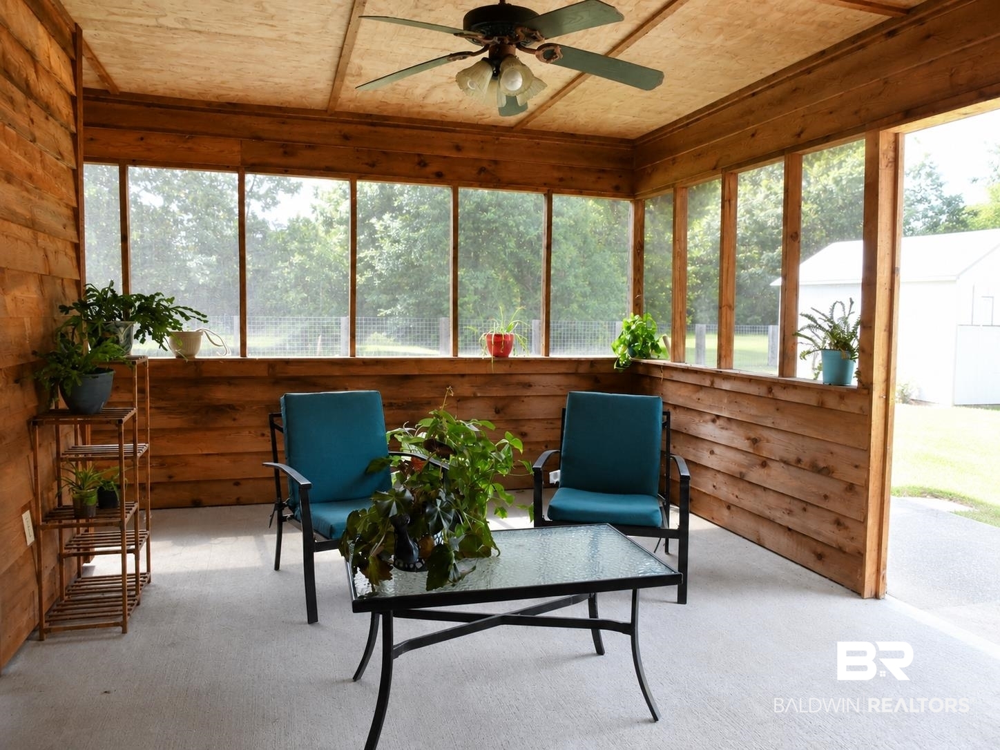 21733 Sedlack Road Silverhill, AL 36576 - Photo 21 of 22 Screened-in porch featuring wood-paneled walls and a light-colored ceiling with a ceiling fan