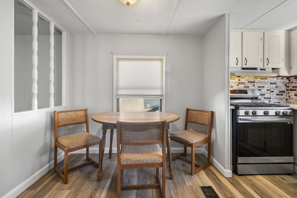 75 South Policy Street, Unit 48 Salem, NH 03079 - Photo 13 of 36 a view of a dining room with furniture and wooden floor