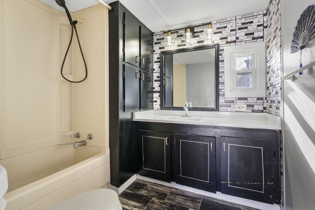 75 South Policy Street, Unit 48 Salem, NH 03079 - Photo 23 of 36 a bathroom with a granite countertop sink and a mirror