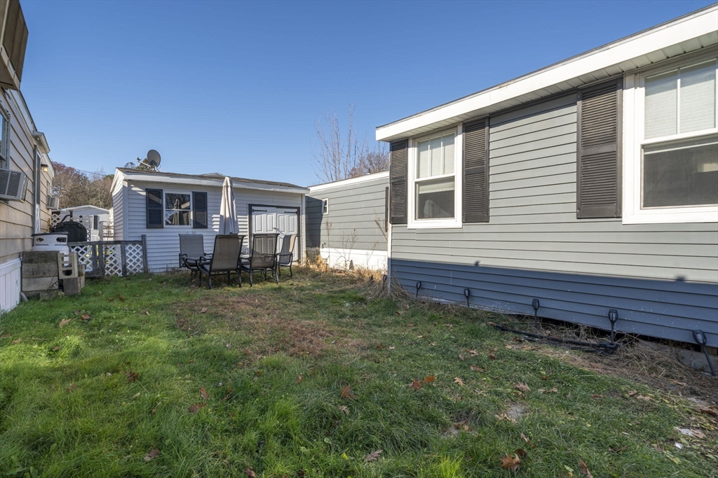 75 South Policy Street, Unit 48 Salem, NH 03079 - Photo 29 of 36 a view of a house with a backyard and chairs