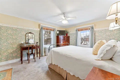 a bedroom with a bed large window and table