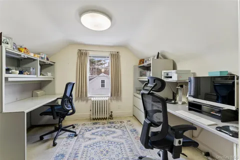 a view of a workspace with furniture and a window