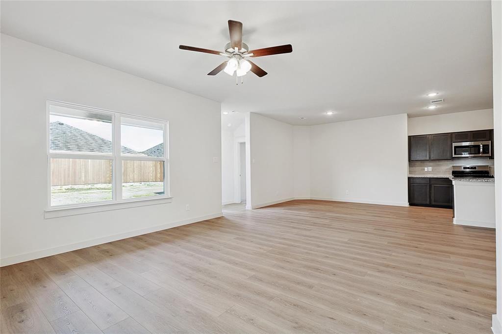 1759 Gleasondale Place Forney, TX 75126 - Photo 10 of 25 Unfurnished living room featuring light wood-type flooring and ceiling fan