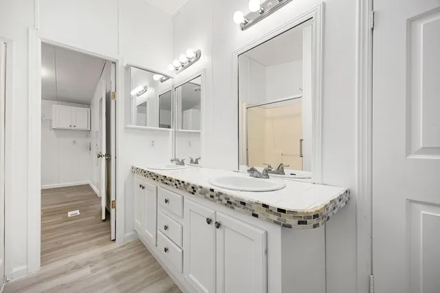 a spacious bathroom with a granite countertop sink mirror and a shower