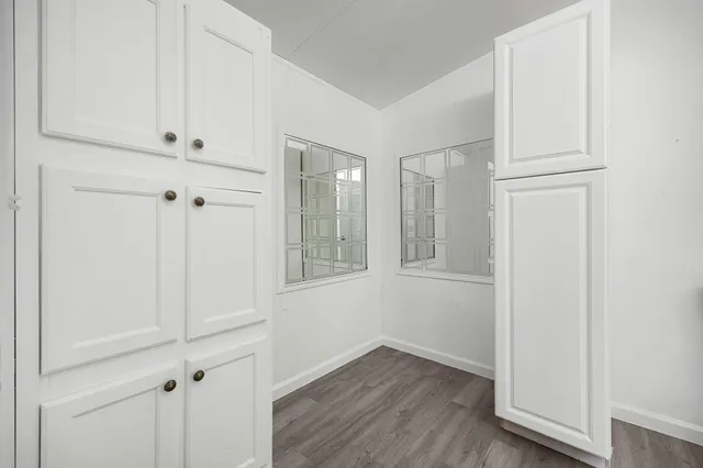 a view of an empty room with wooden floor