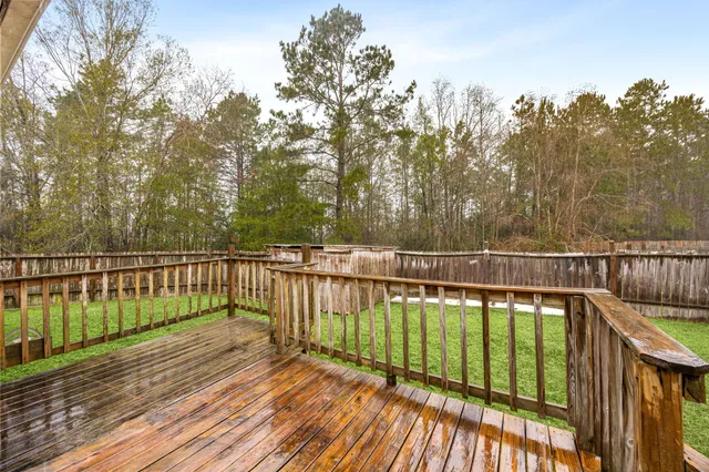 a view of a balcony with wooden floor and fence