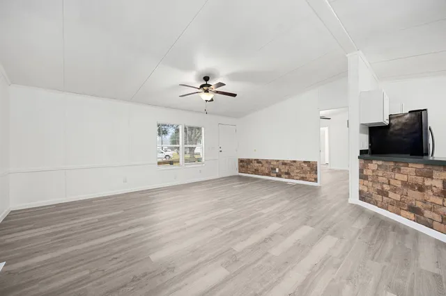 a view of a livingroom with wooden floor and a ceiling fan