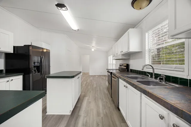 a kitchen with granite countertop a sink stove and refrigerator