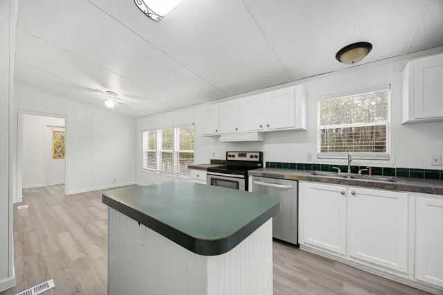 a kitchen with granite countertop a stove sink and cabinets